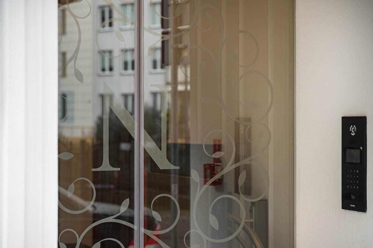 Monogram N trawiony w szkle drzwi wejściowych
